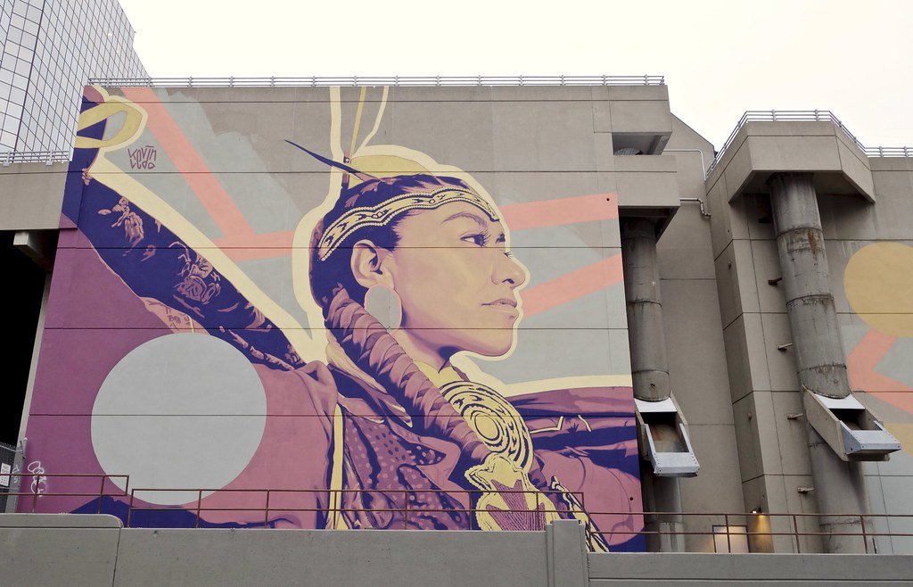 mural of Indigenous woman in regalia on side of building in Calgary
